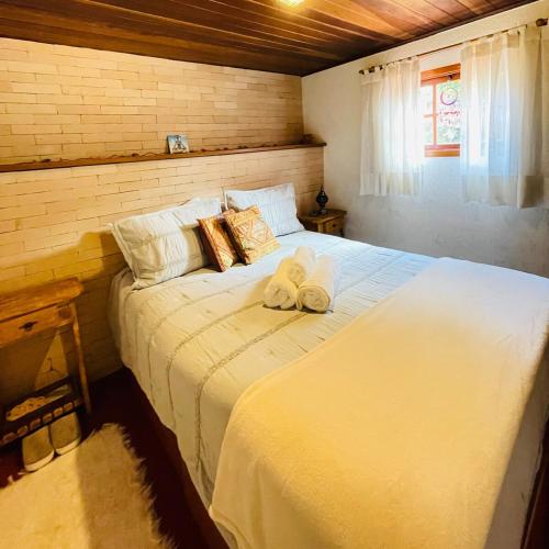 a bedroom with a bed with two towels on it at Vale Vijaya bem estar em meio à natureza in Teresópolis