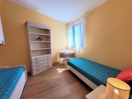 a small room with two beds and a dresser at IseoLakeRental - The View in Solto Collina