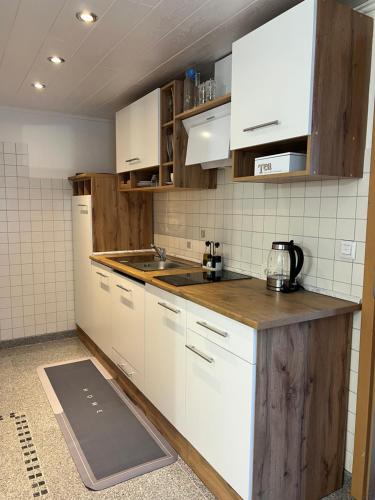 a kitchen with white cabinets and a wooden counter top at Zum Sterngässchen in Ludwigshafen am Rhein