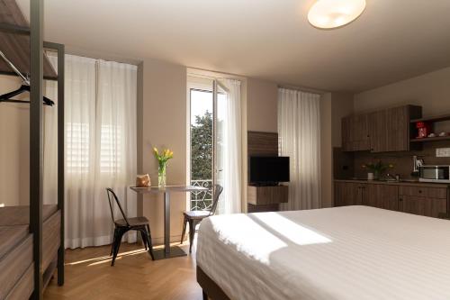 a bedroom with a bed and a table and a window at Residence Villa Bottacin in Trieste