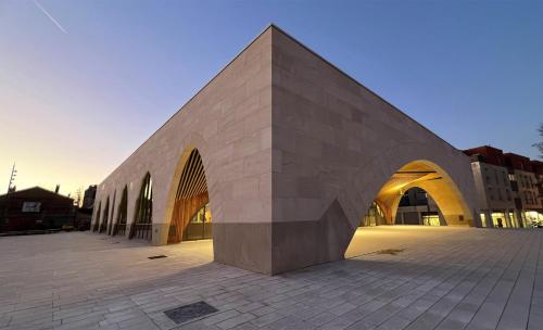 a large stone building with an arch in a plaza at Moulins F4 en centre ville Saint Dizier in Saint-Dizier