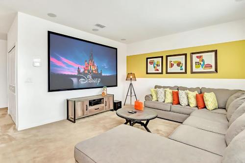 a living room with a couch and a flat screen tv at Family Home with Cinema Pool and BBQ Near Disney in Kissimmee