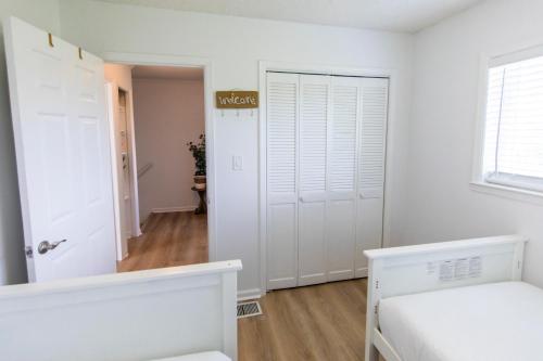 a white bedroom with a white door and a hallway at Whispering Sands #2b in Coffeyville