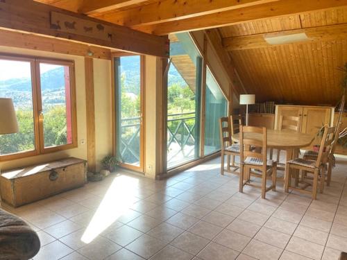d'une salle à manger avec une table et quelques fenêtres. dans l'établissement St-Jorioz Maison vue lac et montagnes 6pers, à Saint-Jorioz