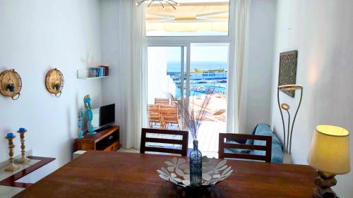 una sala da pranzo con un tavolo e una grande finestra di Casa del Sol a Morro del Jable