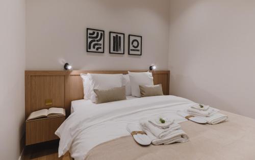 une chambre avec un grand lit blanc avec des serviettes dessus dans l'établissement Large and Calm 2BR Apt with AC & Patio, à Paris