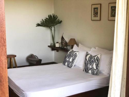 a bedroom with a bed with white sheets and pillows at Espaço Eslovaquia - Casarão com Piscina, Paz e Conexão com a Natureza in Atibaia