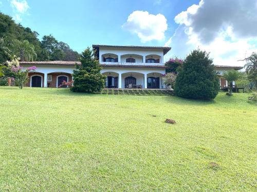 a large house with a large yard in front of it at Espaço Eslovaquia - Casarão com Piscina, Paz e Conexão com a Natureza in Atibaia
