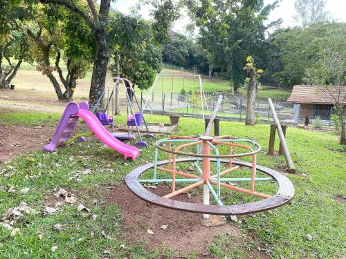 a playground with a slide and a swing at Espaço Eslovaquia - Casarão com Piscina, Paz e Conexão com a Natureza in Atibaia