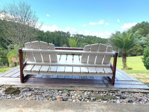 two white chairs sitting on top of a wooden deck at Espaço Eslovaquia - Casarão com Piscina, Paz e Conexão com a Natureza in Atibaia