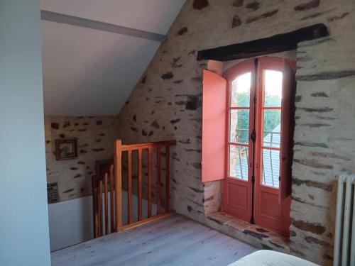a room with a red door and a window at Gîte les 3 petits porcelets in Missillac