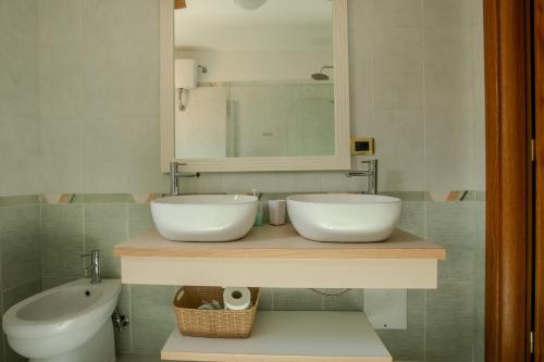 a bathroom with a sink and a toilet and a mirror at Casa Vacanze La Piazzetta in Nusco