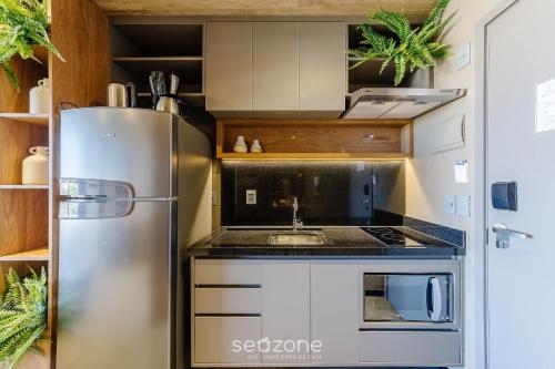 a kitchen with a stainless steel refrigerator and a sink at NWTs - Estúdios em Prédio com Vista Mar in Maceió