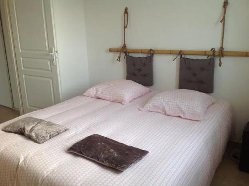 un lit blanc avec deux oreillers dessus dans l'établissement Appartement T2 Magnifique vue mer, à LʼÎle-Rousse