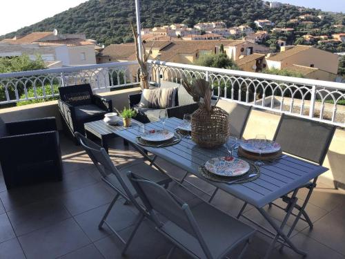 une table bleue et des chaises sur un balcon dans l'établissement Appartement T2 Magnifique vue mer, à LʼÎle-Rousse