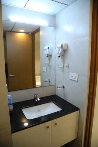 a bathroom with a sink and a mirror at The Sapphire Suite in Trivandrum