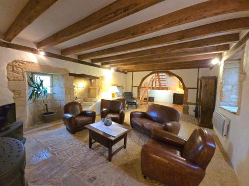 un salon avec des meubles en cuir et une table dans l'établissement Le logis de Contie, à Archignac