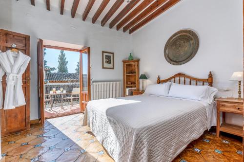 a bedroom with a bed and a balcony at Carmen de los Moriscos - Alhambra views in Granada