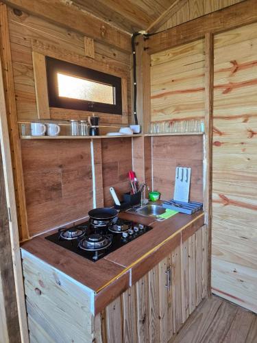 a kitchen with a stove and a sink in a cabin at Mountain refuge - Cabin with wonderful views! in La Búcara