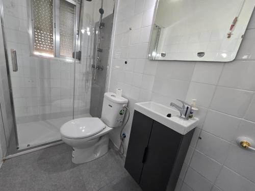 a bathroom with a toilet and a shower and a sink at Villa con piscina y barbacoa para 13 personas cerca del metro in Valencia