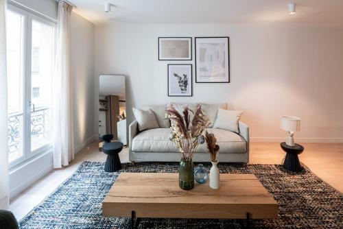 un salon avec un canapé et une table dans l'établissement 2BR Apt with AC - ideal nest for families, à Paris