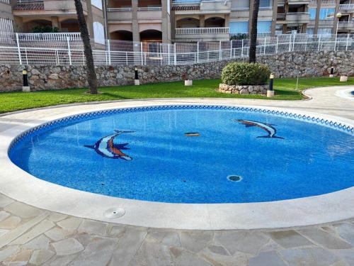 a swimming pool with dolphins in the middle of it at Bahia Park Résidence in Cullera