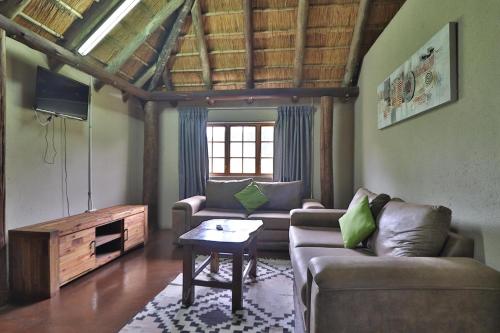 a living room with a couch and a table at Kruger View Chalets in Malelane