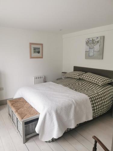 a bedroom with a bed with a blanket on it at The Flower House in Madron