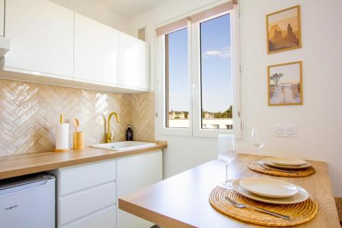 La cuisine est équipée de placards blancs, d'un évier et d'un comptoir. dans l'établissement L'Arizona - 2 min de la Gare - Lit Queen Size, à Corbeil-Essonnes