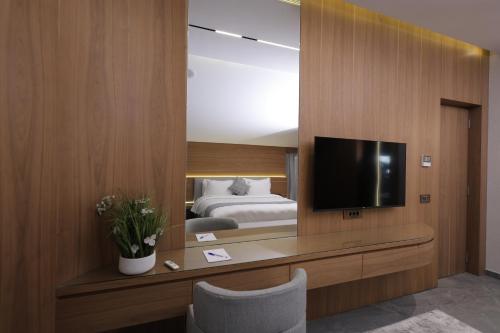 a bedroom with a bed and a television on a wall at Heaven Prestige Hotel in Jounieh