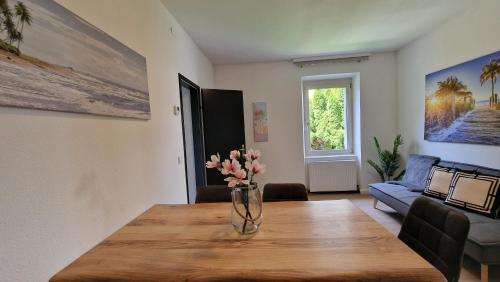 a vase of flowers on a wooden table in a living room at homy Lakeside Symphony in Bregenz am Bodensee in Bregenz