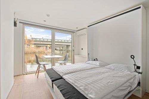 una camera da letto con un letto, un tavolo e delle sedie di HouseBoat the New Lake - Nieuwe Meer ad Amsterdam