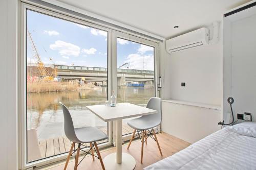a bedroom with a table and two chairs in front of a window at HouseBoat the New Lake - Nieuwe Meer in Amsterdam