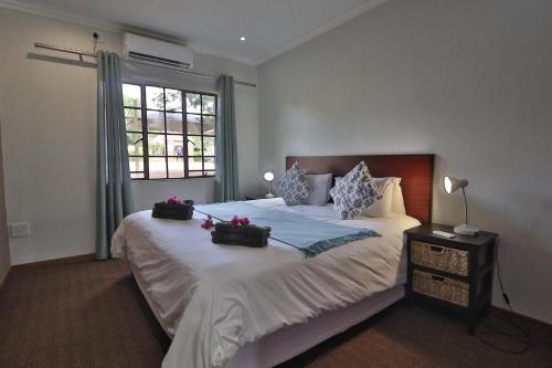 a bedroom with a bed with two bags on it at Kruger View Chalets in Malelane