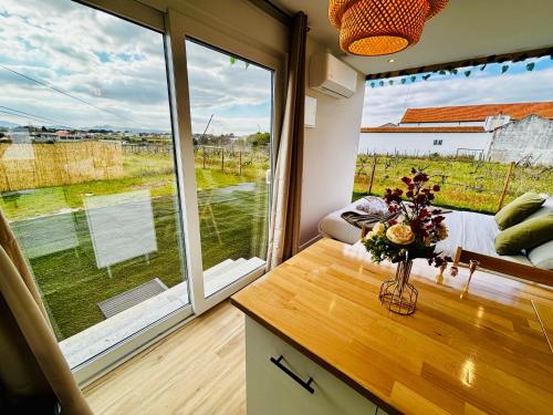a room with a large window and a table with flowers at Refugio do Gato in Palmela