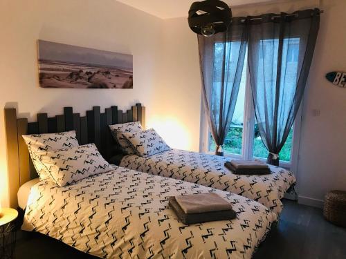 une chambre avec deux lits et une fenêtre dans l'établissement St Georges d'Oléron maison de village, à Saint-Georges-dʼOléron