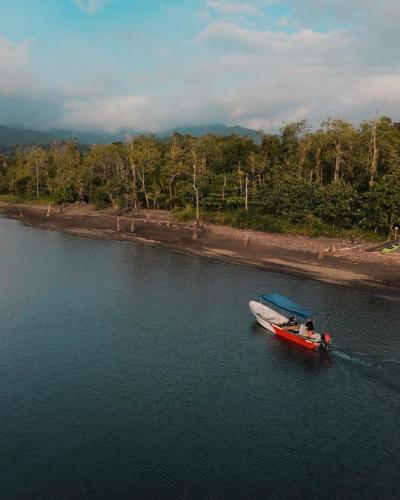 a small boat in the water near a beach at playa mecana kirita in Bahía Solano