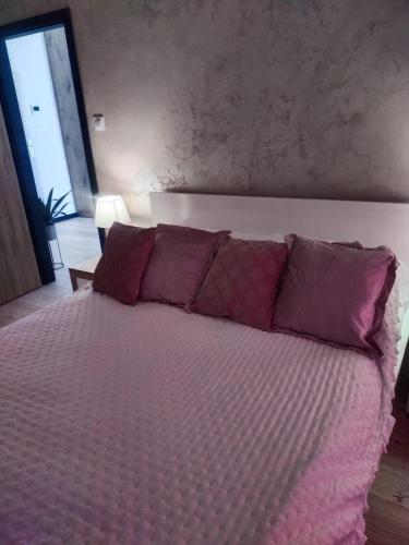 a bedroom with a large bed with purple pillows at Grunwaldzka 65 Elbląg in Elblag
