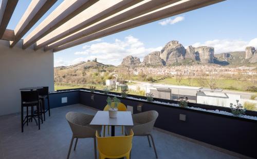 a balcony with a table and chairs and mountains at Mirabilis Boutique Hotel by Panel Hospitality in Kalabaka
