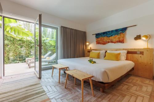 een slaapkamer met een groot bed en een balkon bij Laranjal Farm House in Moncarapacho