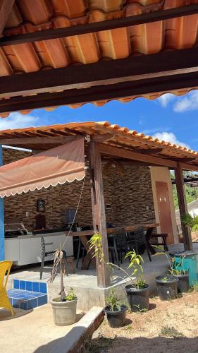 ein Haus mit einer Terrasse mit Pflanzen in Töpfen in der Unterkunft Margarida 03 in Monte das Gameleiras
