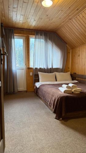 a bedroom with a large bed with two hats on it at Гостинний двір" Живиця" ЧАН in Mizhhirʼʼya