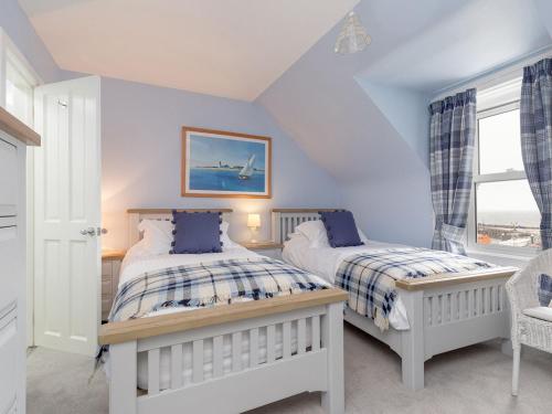 a bedroom with two beds and a window at Holiday Home The Knowe by Interhome in Portpatrick