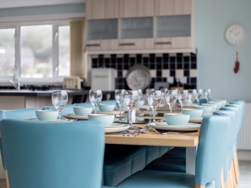 a long table with glasses and plates on it at Holiday Home The Knowe by Interhome in Portpatrick