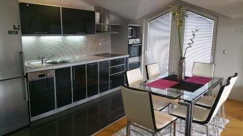 a kitchen with a glass table with chairs and a sink at Comfort Deluxe Kosmos Apartments in Ohrid