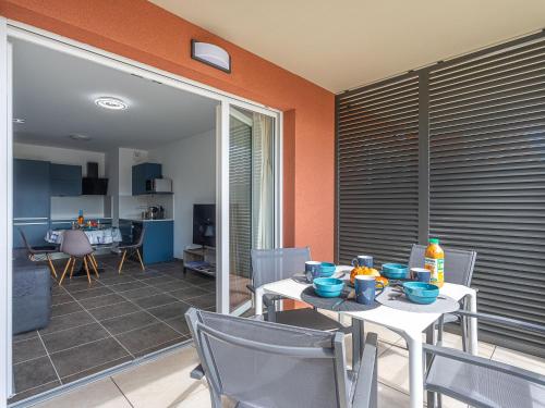 une salle à manger avec une table et des chaises et une cuisine dans l'établissement Apartment Eden Golfe-2 by Interhome, à Cogolin