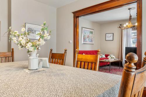 a dining room table with a vase of flowers on it at Stowaway Lower Deck in Sturgeon Bay