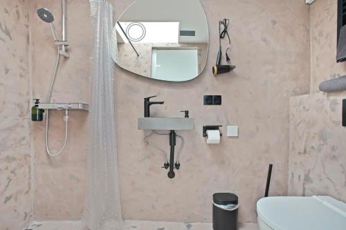 un bagno con doccia, lavandino e specchio di HouseBoat the New Lake - Nieuwe Meer ad Amsterdam