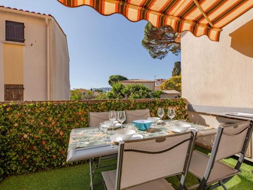 - une table et des chaises sur une terrasse avec un parasol dans l'établissement Studio Les Jardins d'Ys-10 by Interhome, aux Issambres