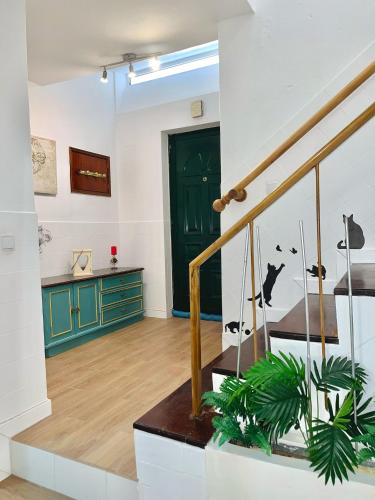 a room with a staircase and a green door at Flor de Laranjeira in Mértola